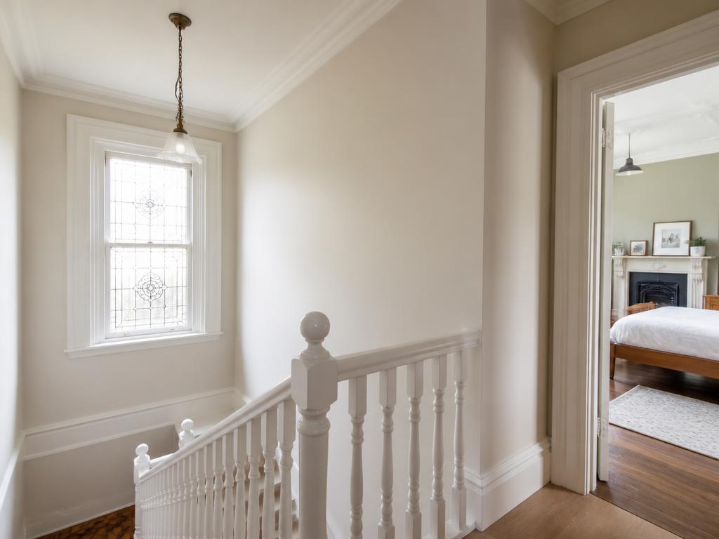 Freshly painted Victorian staircase and landing with white banisters